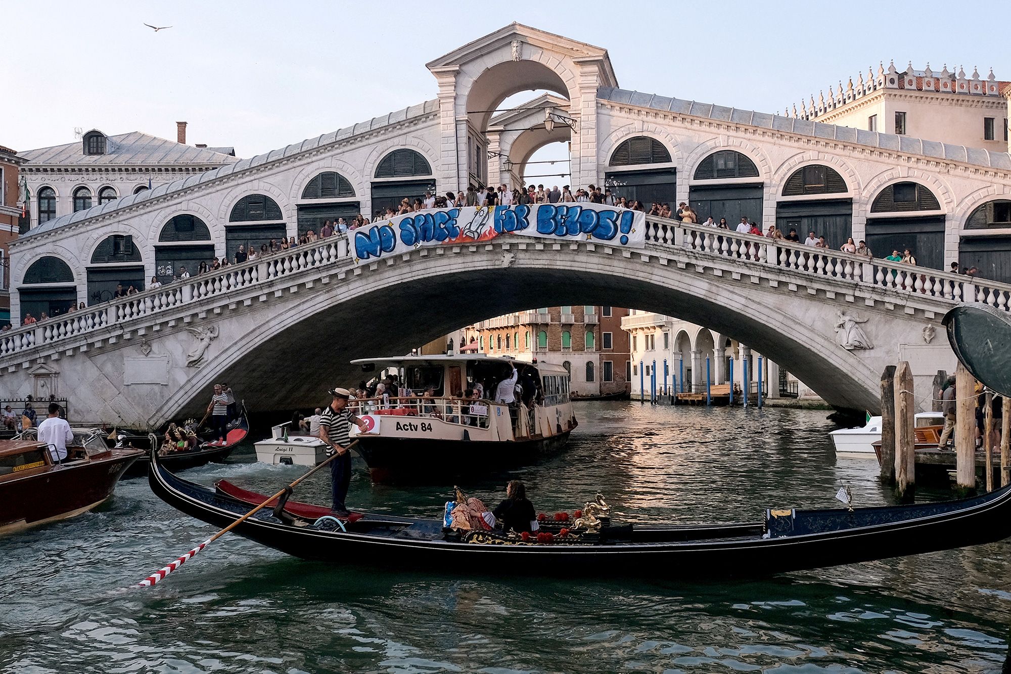 Protesters display a banner reading "No Space for Bezos!" on the Rialto Bridge.