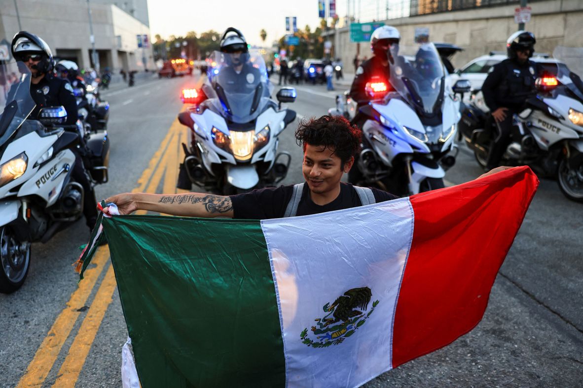 A protestor holds a Mexican flag outside the Edward R. Roybal Federal Building in Los Angeles, on Friday, June 13.