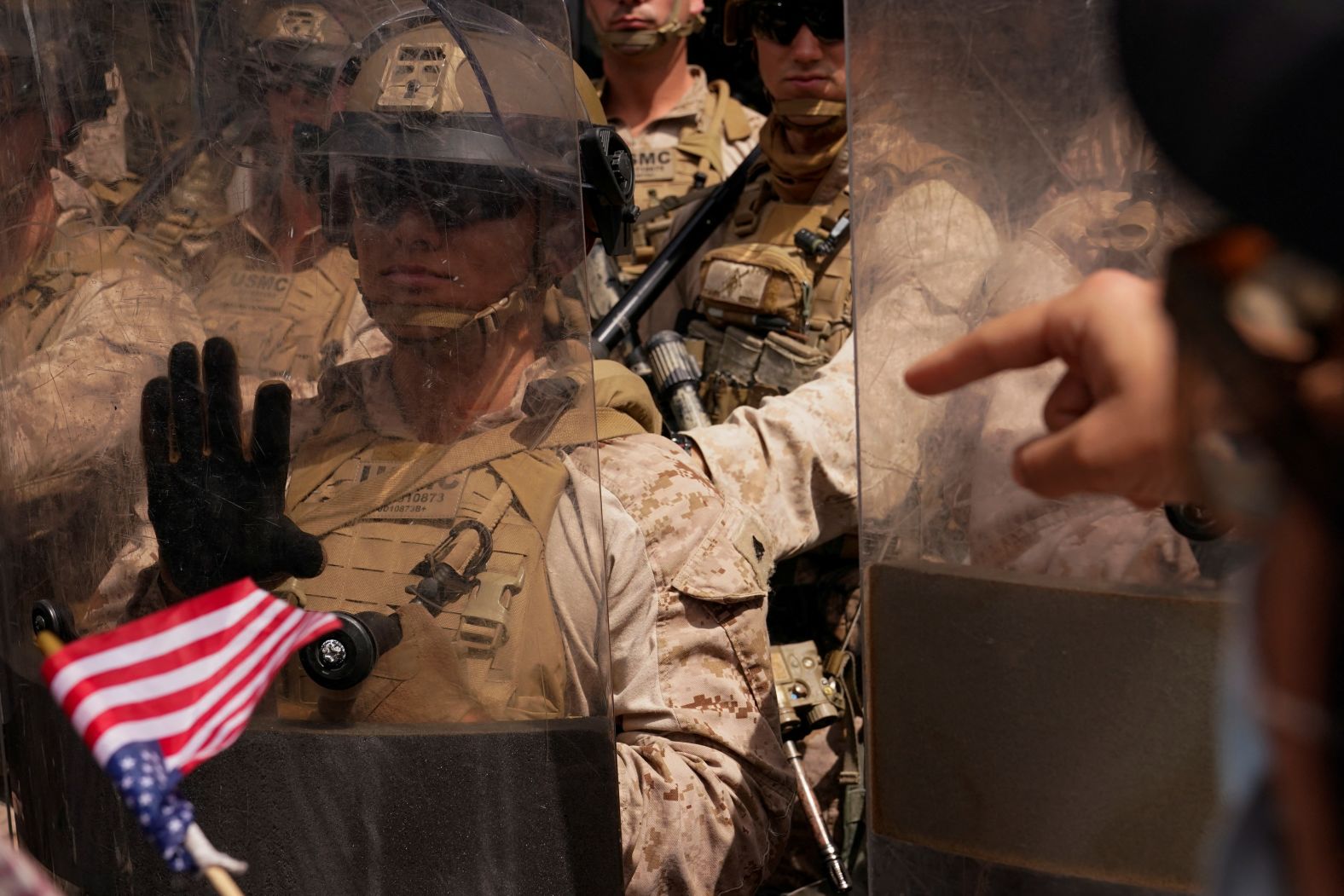 A person gestures toward US Marines standing guard during a demonstration in Los Angeles.