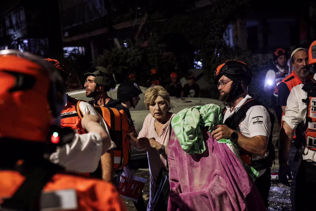 Rescue and security personnel help an injured woman in Bat Yam.