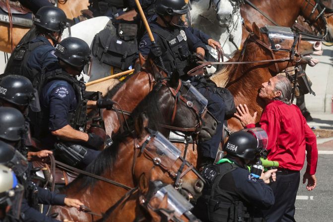 A protester blocks mounted police officers during the "No Kings" protest.