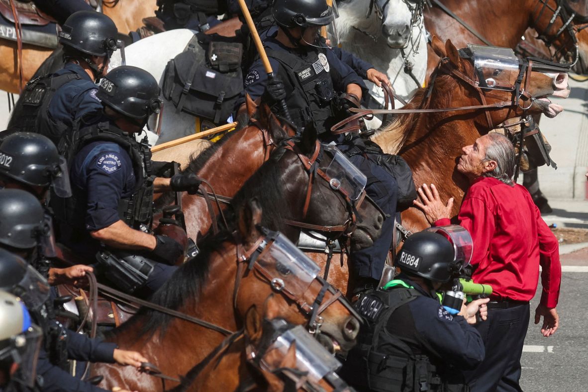 A protester blocks mounted police officers during the "No Kings" protest.