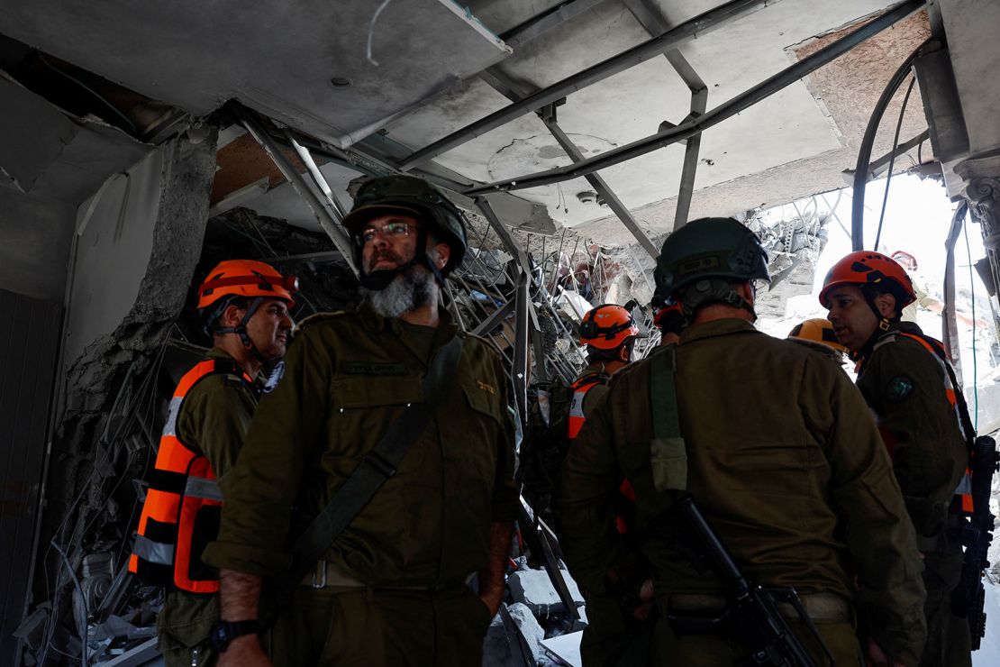 Emergency and security personnel stand inside a damaged building after missiles fired from Iran impacted a residential building, in Tamra, northern Israel June 15, 2025.