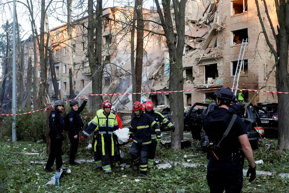 Emergency Service personnel carry a body following Russian strikes on Kyiv on June 23.