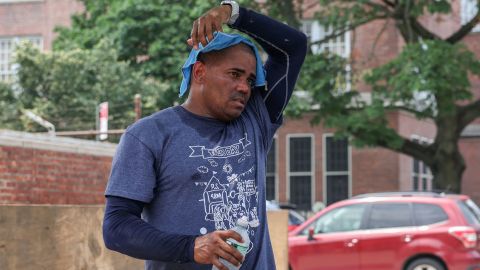 A landscaper puts a cold towel over his head during a heat wave in Queens, New York City, on Monday.