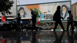 People walk next to a mural with a picture of Iran's Supreme Leader, Ayatollah Ali Khamenei, on a street, early hours of ceasefire, in Tehran, Iran, June 24, 2025.