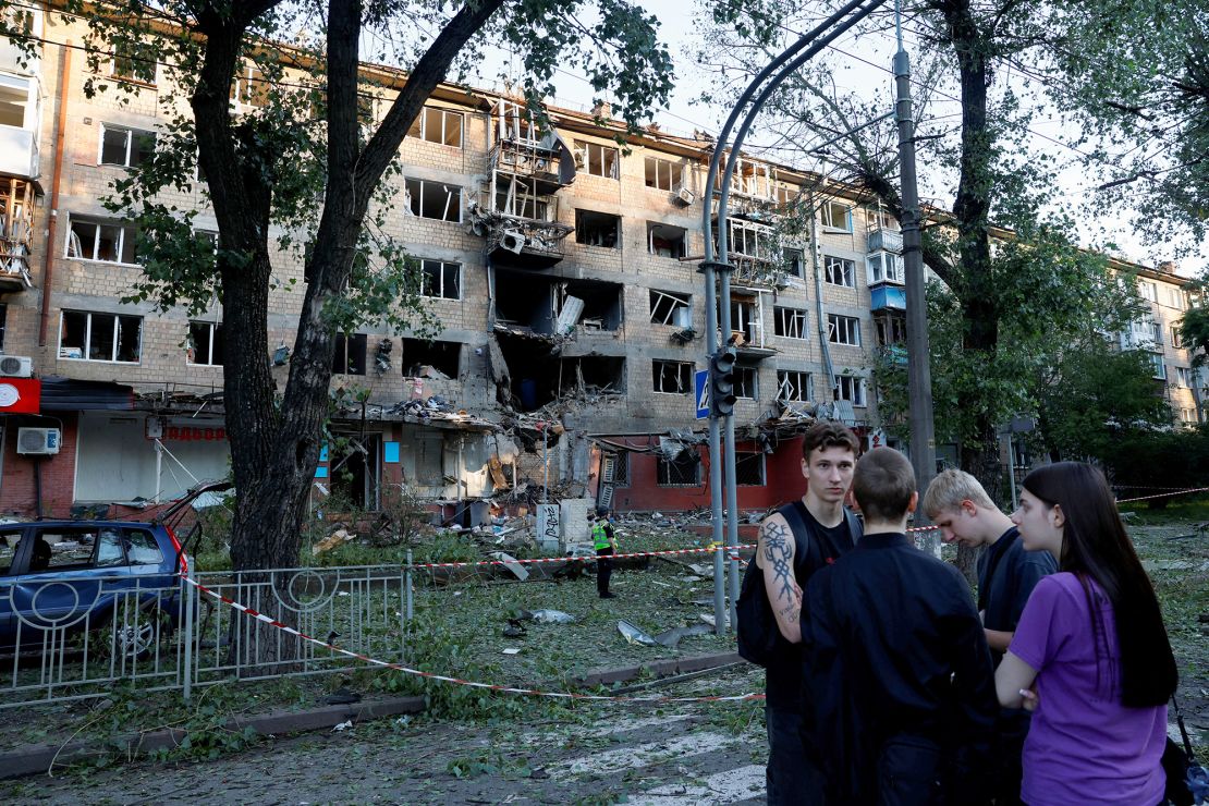 People gather near a building damaged following Russian drone and missile strikes in Kyiv.
