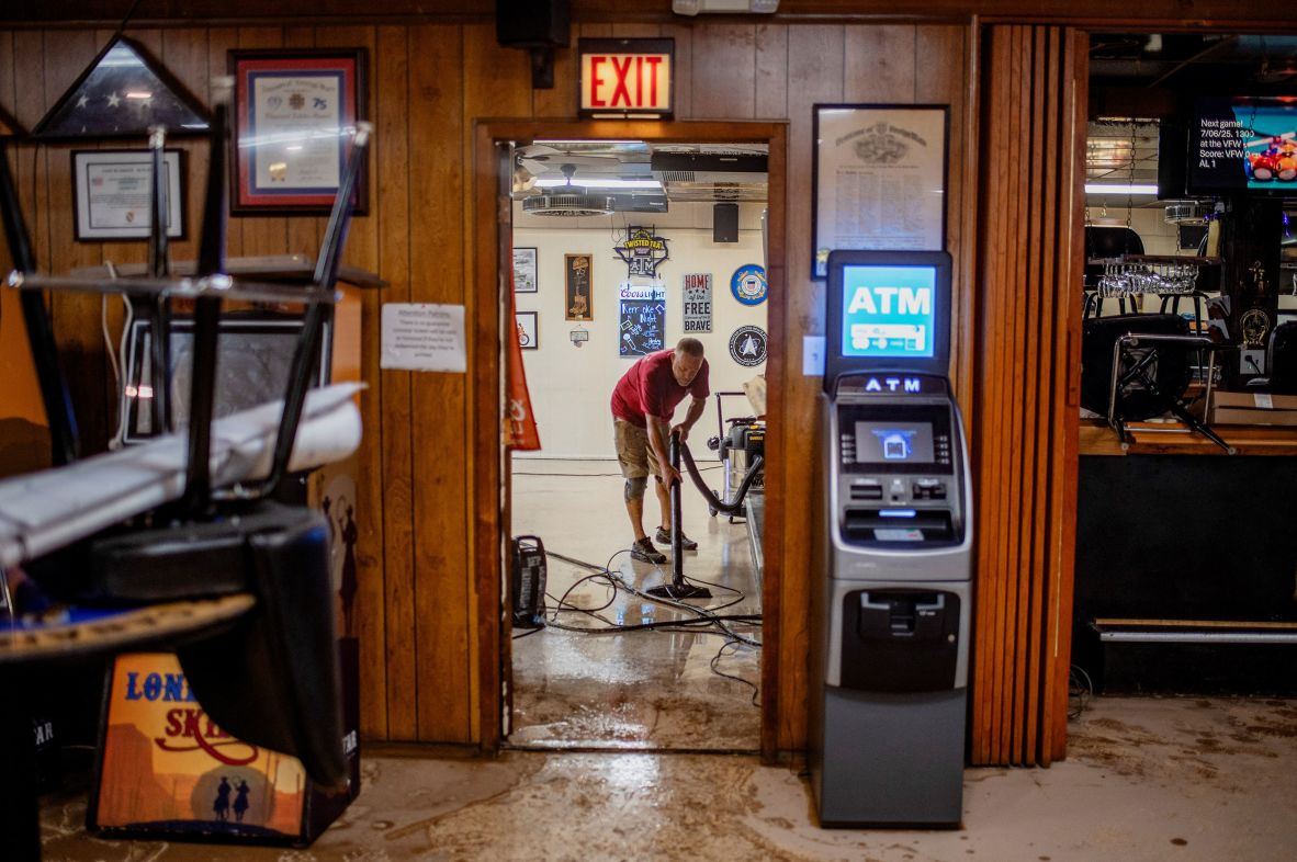 A man vacuums water inside VFW Post 1480 in Kerrville on Saturday.