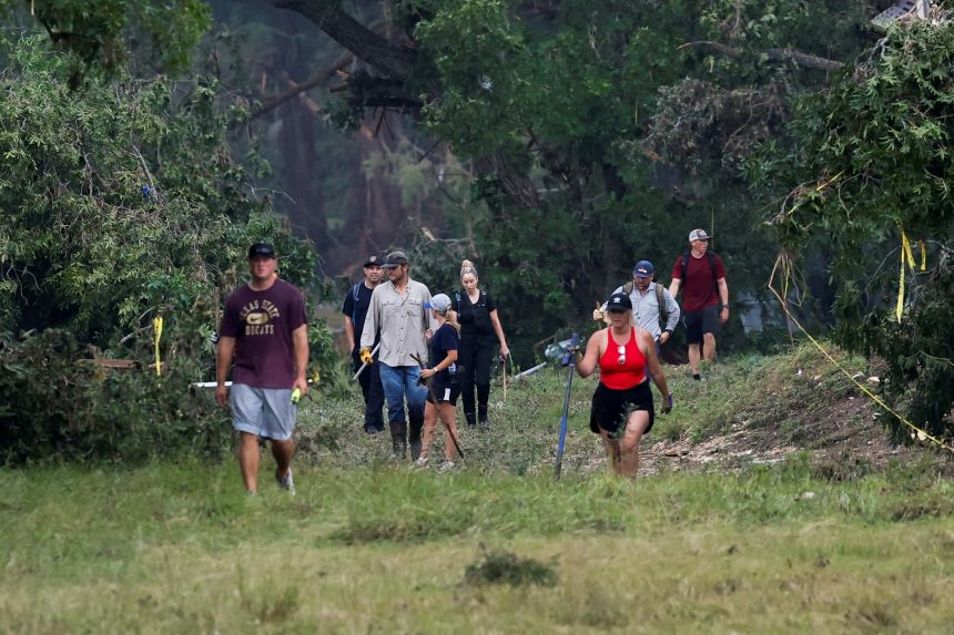 People search the area in Hunt, Texas, on July 6.