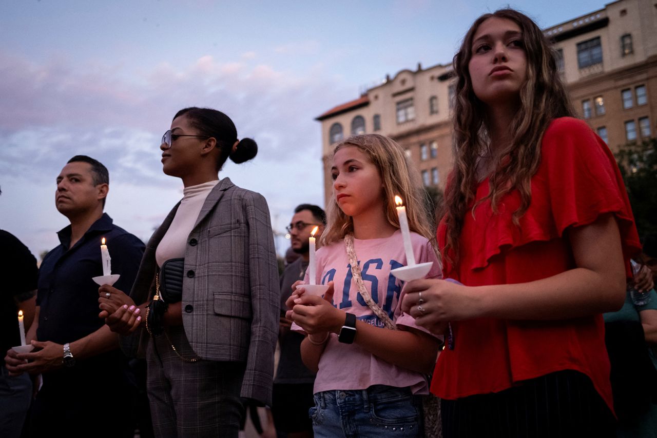 People take part in a vigil in memory of Texas flooding victims, at Travis Park in San Antonio, Texas, on Monday.