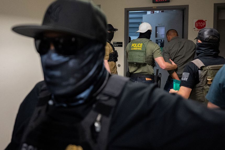 A migrant is detained and escorted July 17 by masked federal immigration officers at a US immigration court in New York.