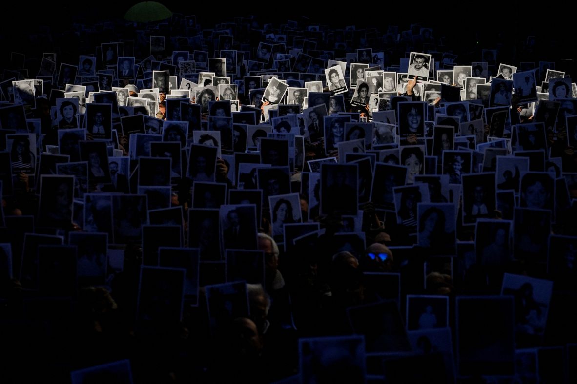People in Buenos Aires hold up photos Friday, July 18, that show those who died in the 1994 bombing of a Jewish community center there. They were marking the 31st anniversary of the attack.