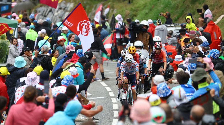 Spectators react as Bahrain Victorious' Lenny Martinez rides during stage 14.