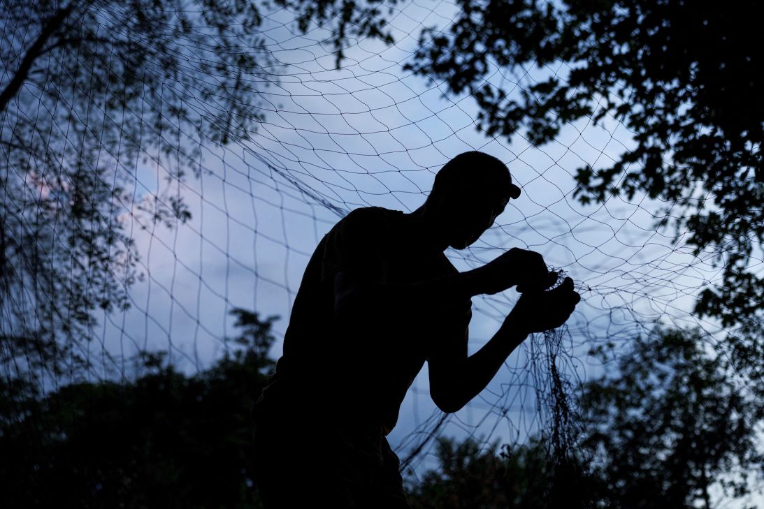 A service member of the 13th Operative Purpose Brigade of the National Guard of Ukraine installs an anti-drone net at a front-line position in Ukraine's Kharkiv region on July 19.