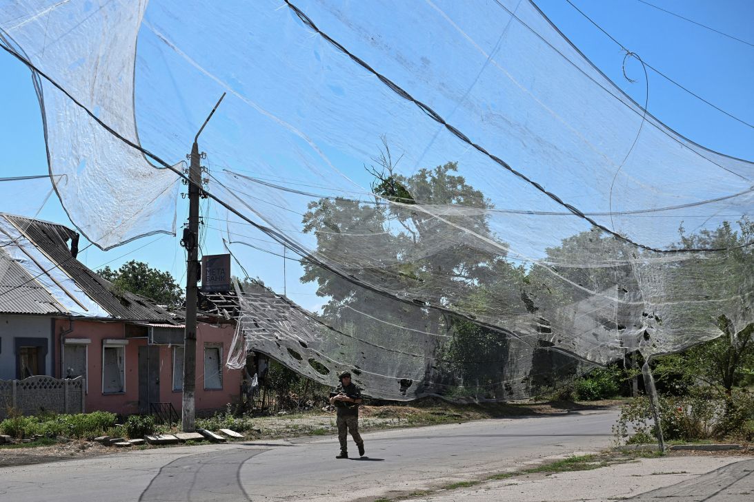 A Ukrainian service member walks on a street protected with anti-drone nets, in the frontline town Orikhiv in the Zaporizhzhia region of Ukraine, on July 23.