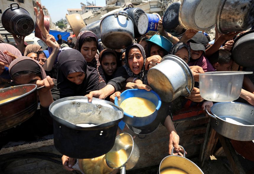 Palestinians gather to receive food from a charity kitchen, amid a hunger crisis, in Gaza City, on Thursday.