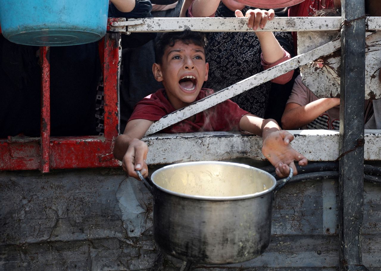 A Palestinian boy reacts as he waits to receive food from a charity kitchen in Gaza City on Monday.