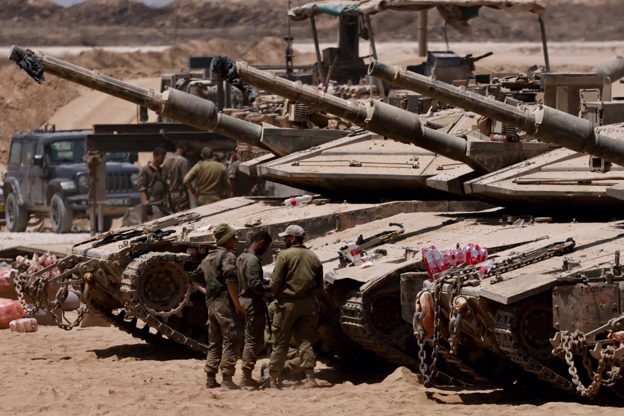 Israeli soldiers work on their tanks near the Israel-Gaza border on July 29.