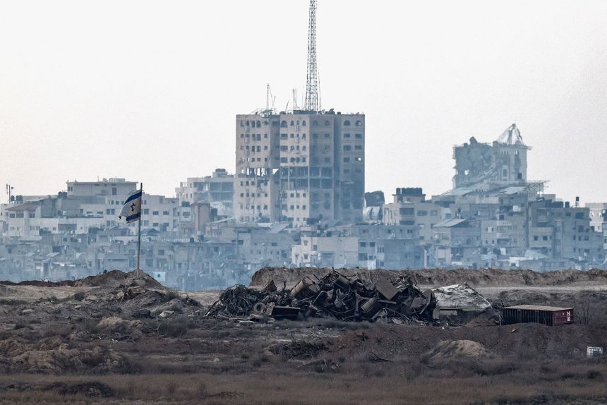 A damaged Israeli flag stands in Gaza, as seen from the Israeli side of the border on Thursday.