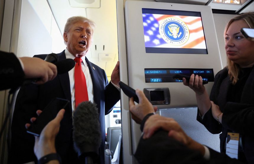 President Donald Trump speaks to reporters aboard Air Force One on his way to Alaska on Friday.