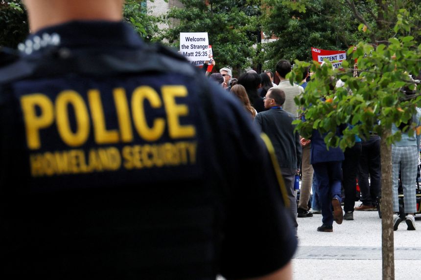 Homeland Security police officer stands behind a press conference called by Boston Mayor Michelle Wu to respond to a letter from US Attorney General Pam Bondi demanding that Boston change its immigration policies, in Boston, Massachusetts on August 19, 2025.