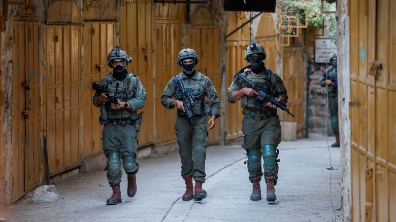 Israeli troops walk during a weekly settlers' tour in Hebron, in the Israeli-occupied West Bank, August 23, 2025. REUTERS/Mussa Qawasma