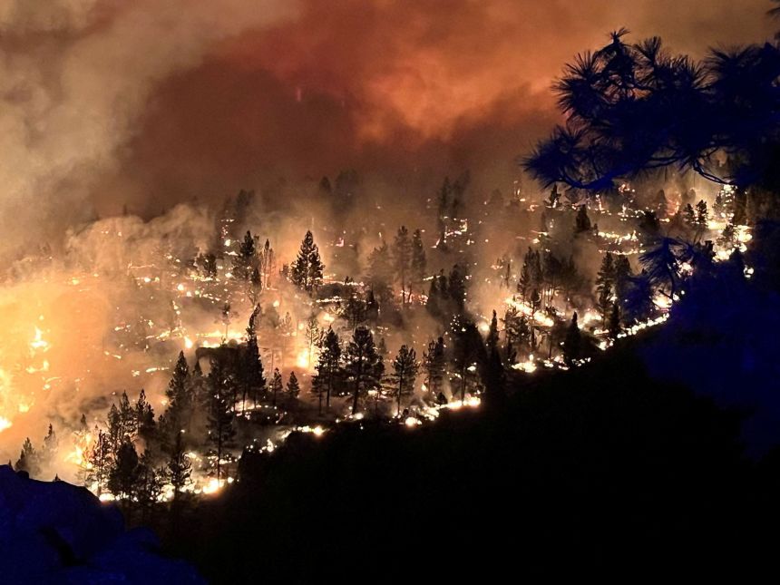 Smoke billows and flames rise from the Flat Fire in a location given as Deschutes County, Oregon, U.S., in this handout image released August 23, 2025.
