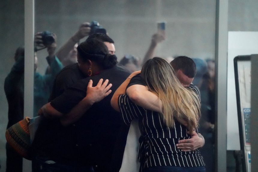 Kilmar Abrego Garcia, the migrant whose wrongful deportation to El Salvador made him a symbol of U.S. President Donald Trump's aggressive immigration policies, hugs his wife Jennifer Vasquez Sura, as appears for a check-in at the ICE Baltimore field office three days after his release from criminal custody in Tennessee, in Baltimore, Maryland, August 25, 2025. Picture taken through glass. REUTERS/Elizabeth Frantz