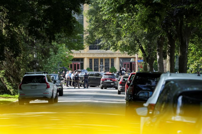 Law enforcement officers gather outside Annunciation Church following a mass shooting event in Minneapolis on Wednesday.