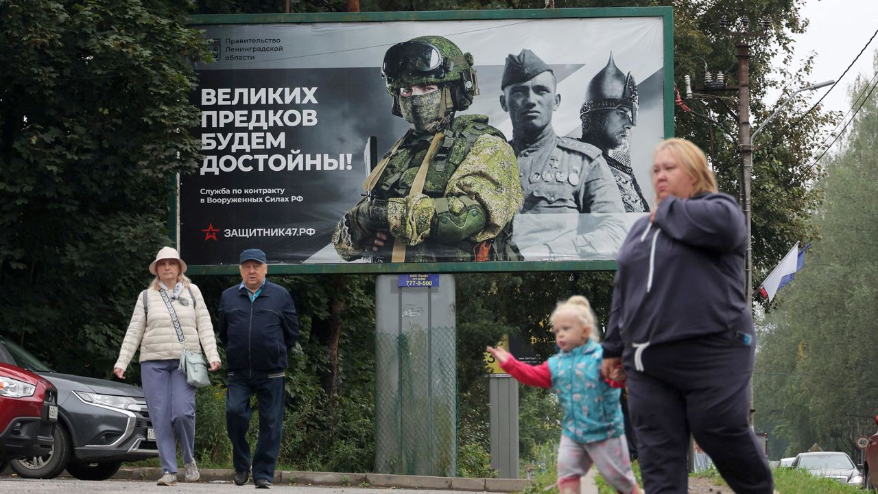 People walk near an advertising board promoting military service under contract with Russian Armed Forces, in Vsevolozhsk, Leningrad Region, Russia August 30, 2025.  REUTERS/Anton Vaganov 