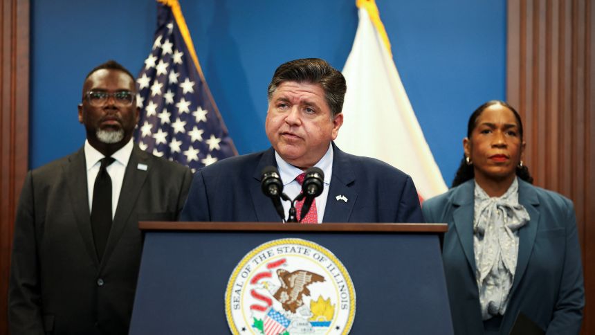 Illinois Governor JB Pritzker, in front of Illinois Lieutenant Governor Juliana Stratton and Chicago Mayor Brandon Johnson, speaks during a press conference on reports of federal deployments in Chicago on Tuesday.