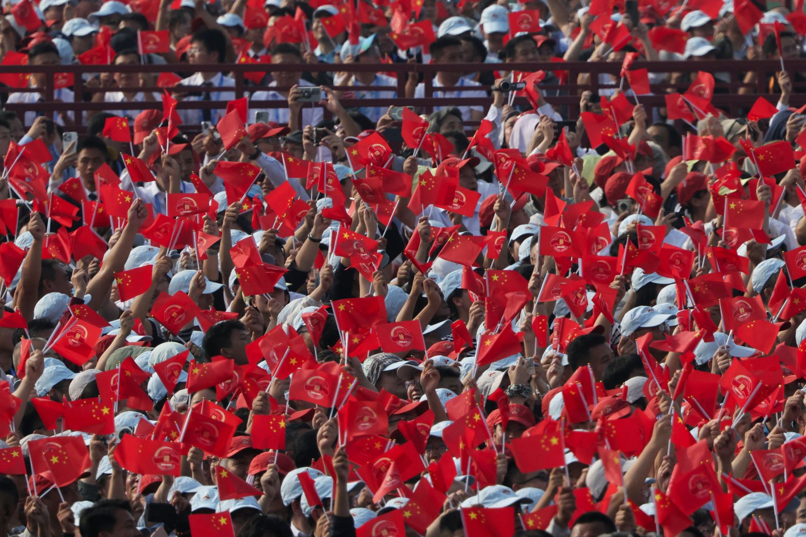Spectators wave flags ahead in celebrate the anniversary at the parade.