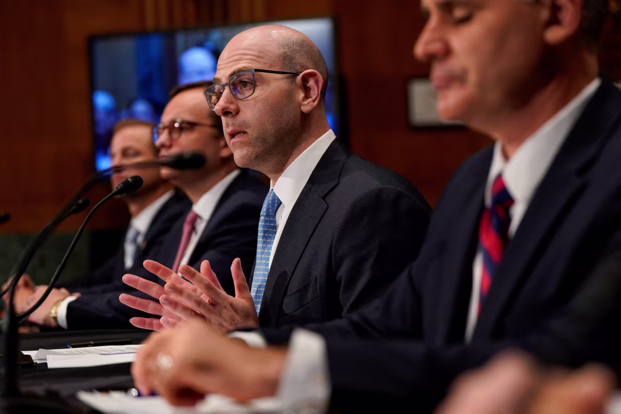 Stephen Miran, center, speaks during a Senate committee hearing earlier this month.