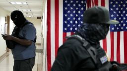 Federal immigration officers wait in a hallway to detain migrants at a US Immigration Court in Manhattan, New York, on September 4.