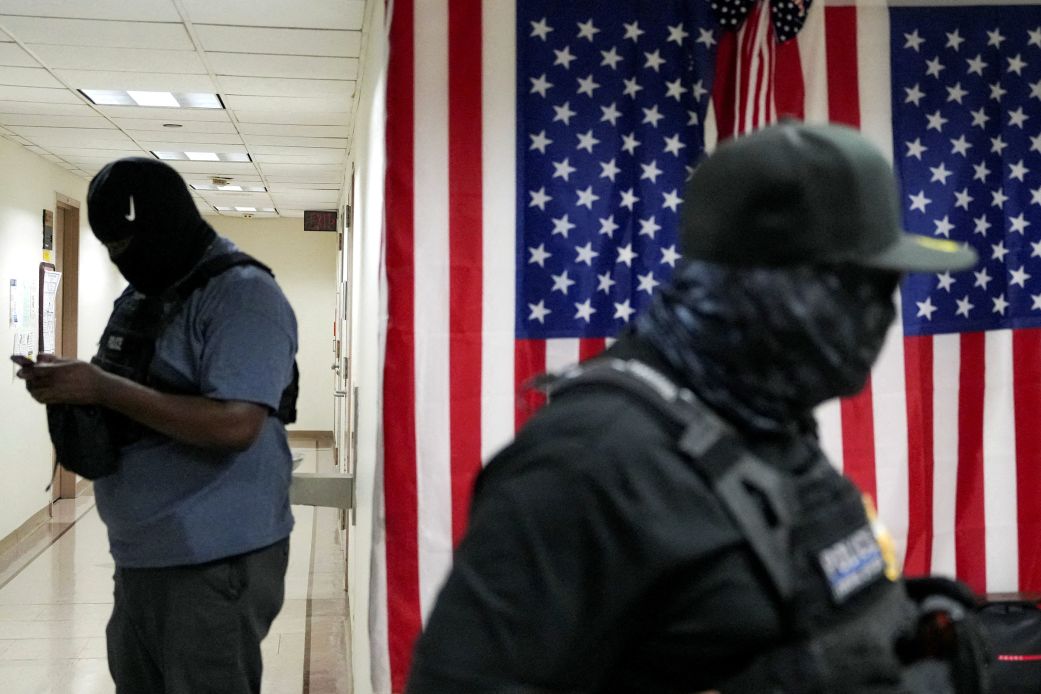Federal immigration officers wait in a hallway to detain migrants at a US Immigration Court in Manhattan, New York, on September 4.