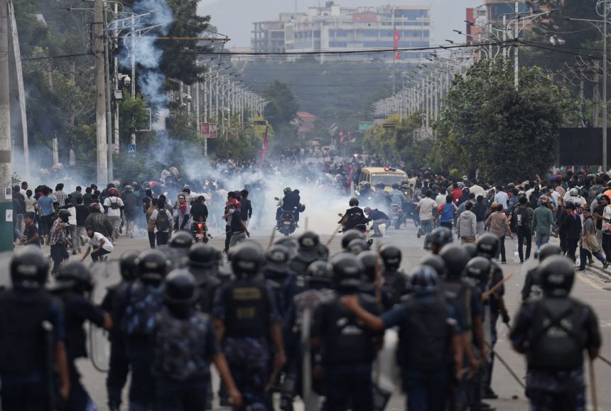 Riot police personnel chase demonstrators in the Nepalese capital during Monday's protest.