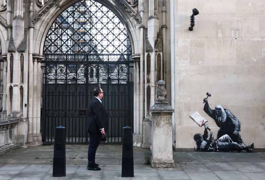 A person looks at a new mural by anonymous artist Banksy on the Royal Courts of Justice in London, on September 9, 2025.