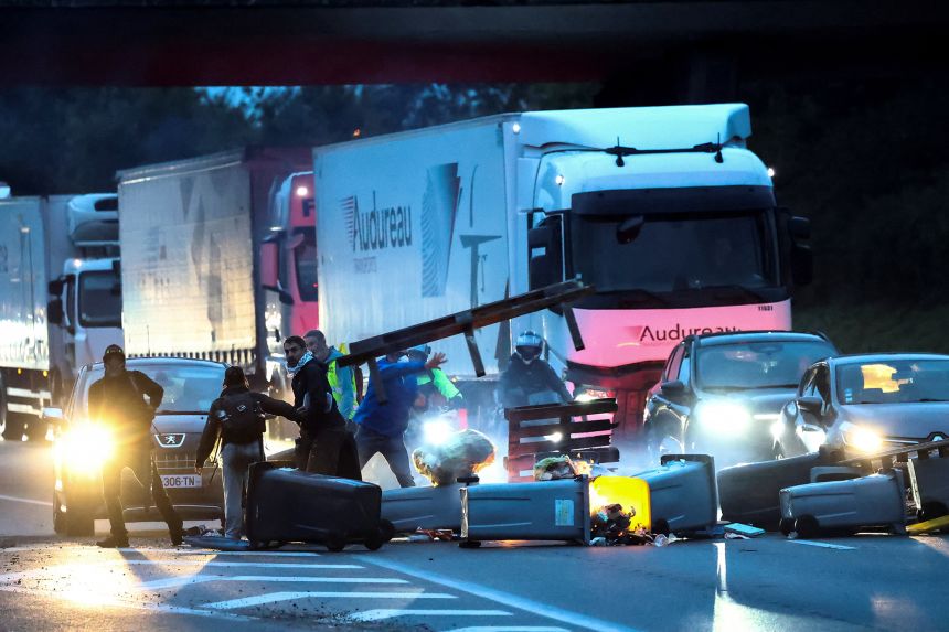 Demonstrators throw garbage containers and other objects to block traffic on the ring road in Nantes as part of the 
