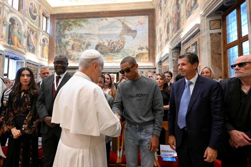 Pope Leo shakes hands with American singer Pharrell Williams at the Vatican, on Friday. A varied mix of thinkers and music artists convened to discuss everything from agriculture to sport.