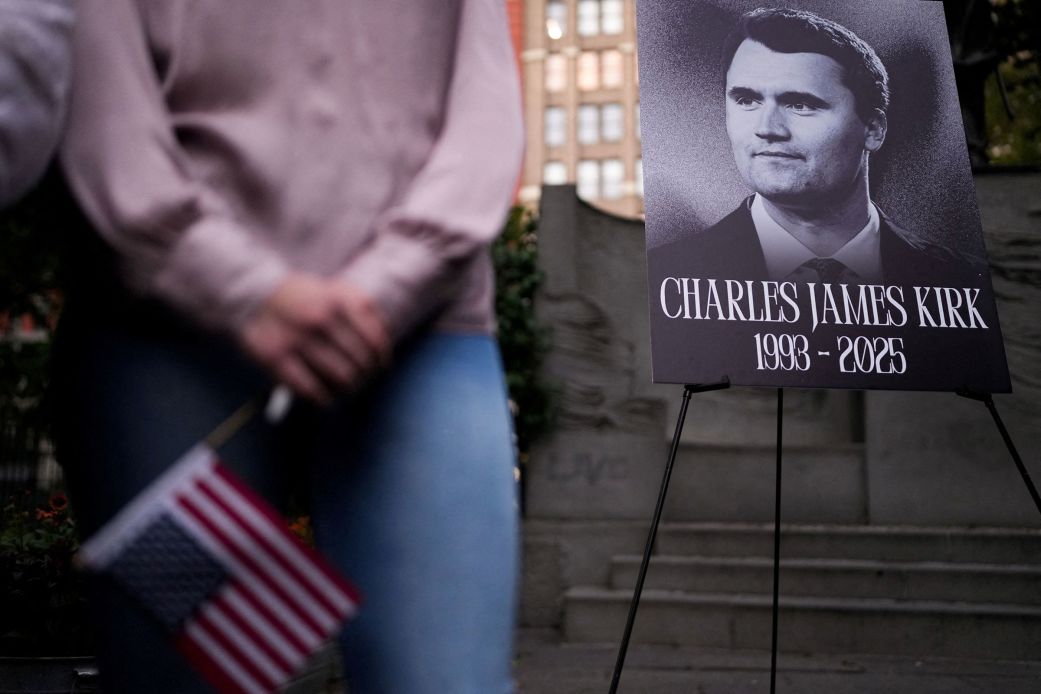 A person holds a US flag as people gather during a vigil for Charlie Kirk at Madison Square Park in New York on September 12.