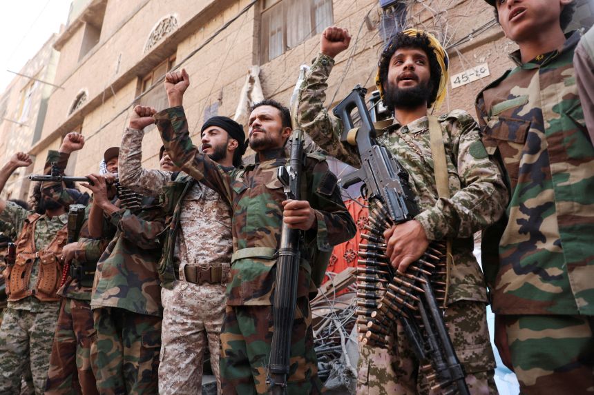 Houthi fighters carry weapons as they stand near the site of Israeli airstrikes, in Sanaa, Yemen September 13, 2025.