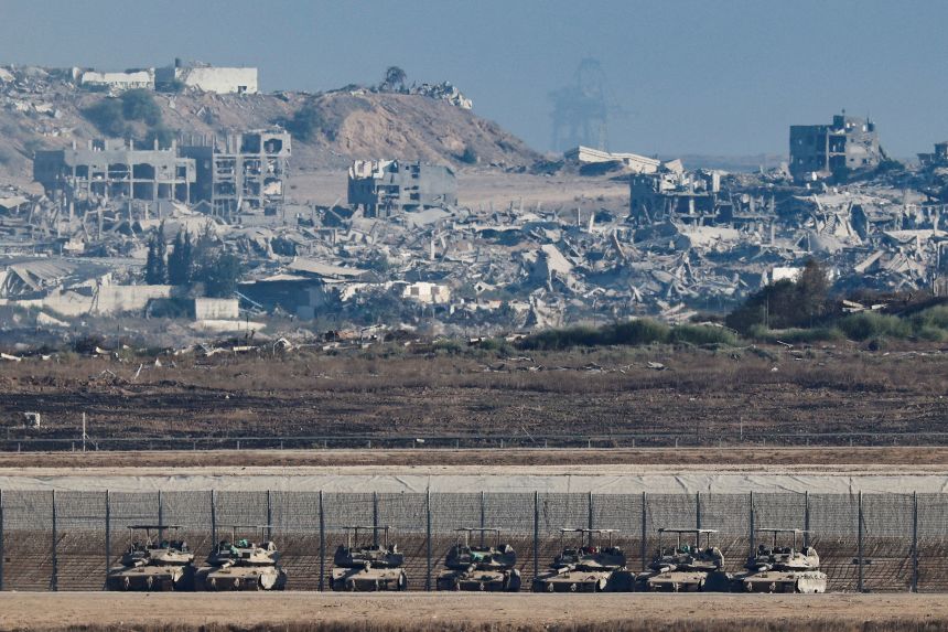 Tanks stand on the Israeli side of the border, as destruction in Gaza is seen in the background, in Israel September 16.