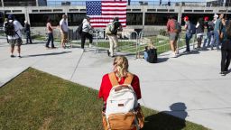 A young woman prays near the site, where Charlie Kirk was fatally shot, as students return to classes at Utah Valley University in Orem, Utah, on September 17.