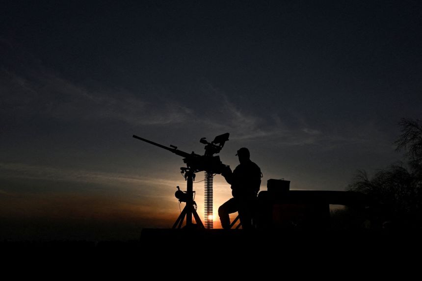 A Ukrainian service member stands next to an M2 Browning machine gun, during a combat shift on the front line in Ukraine's Kharkiv region, on September 15.