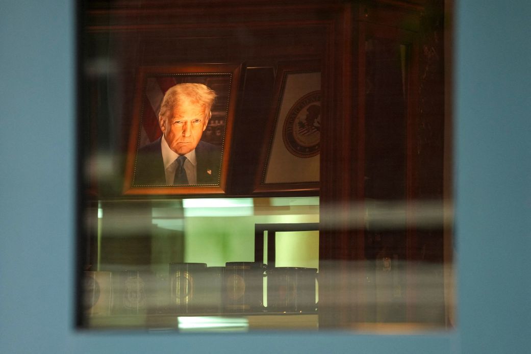 A photograph of President Donald Trump is lit up at the entranceway of Justin W. Williams United States Attorney's building, adjacent to US District Court in Alexandria, Virginia, on Thursday.