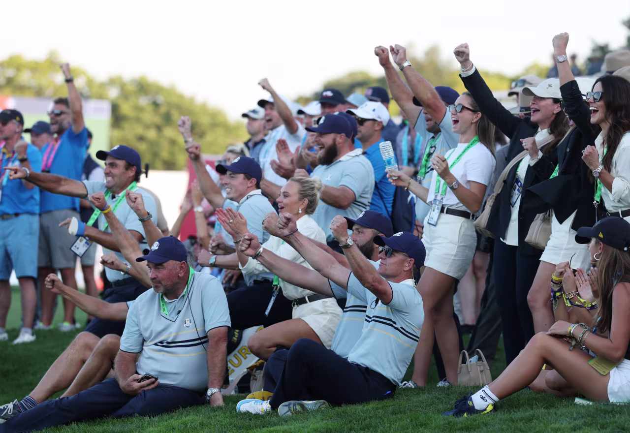 Team Europe captain Luke Donald, bottom center, is joined by players and families on the 18th hole on Friday.