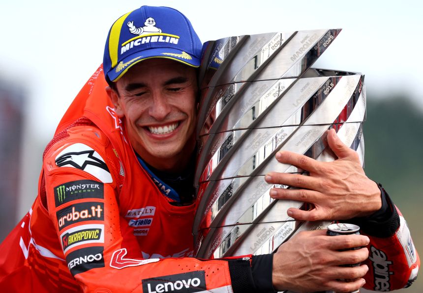 Márquez celebrates with the trophy after winning the 2025 MotoGP World Championship.