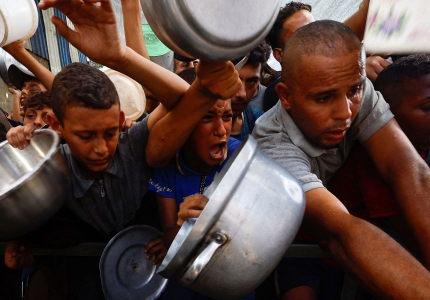 Palestinians gather to receive food from a charity kitchen, in Nuseirat, central Gaza on Sunday, September 28.