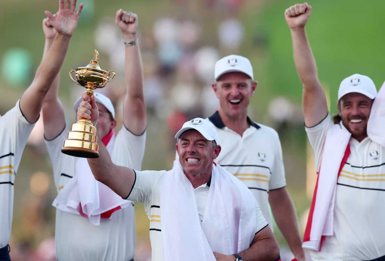Rory McIlroy and his Team Europe teammates celebrate with the Ryder Cup trophy.