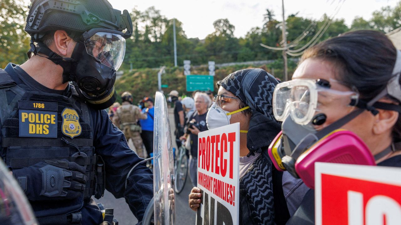 A Federal Protective Service officer stands guard in front of demonstrators as protests against Immigration and Customs Enforcement (ICE) draw hundreds to the ICE headquarters in south Portland, Oregon, U.S., September 28, 2025.
